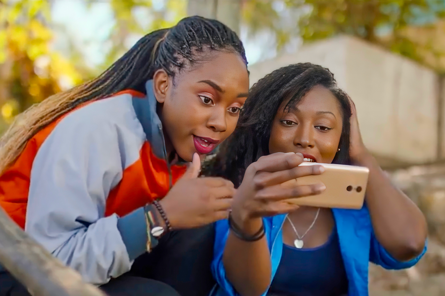 Two young women using their mobile phone to connect with friends
