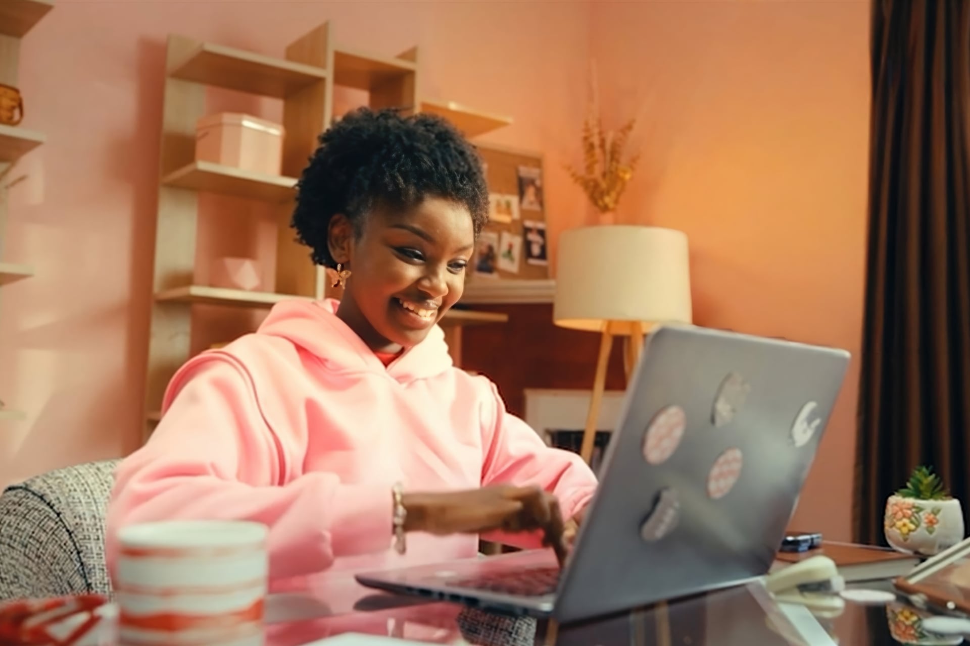 Young woman sitting at a table typing at her laptop