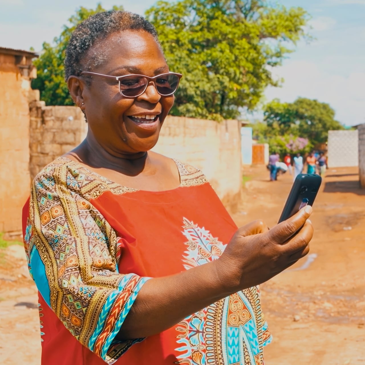 Older lady in sunglasses looking at her phone