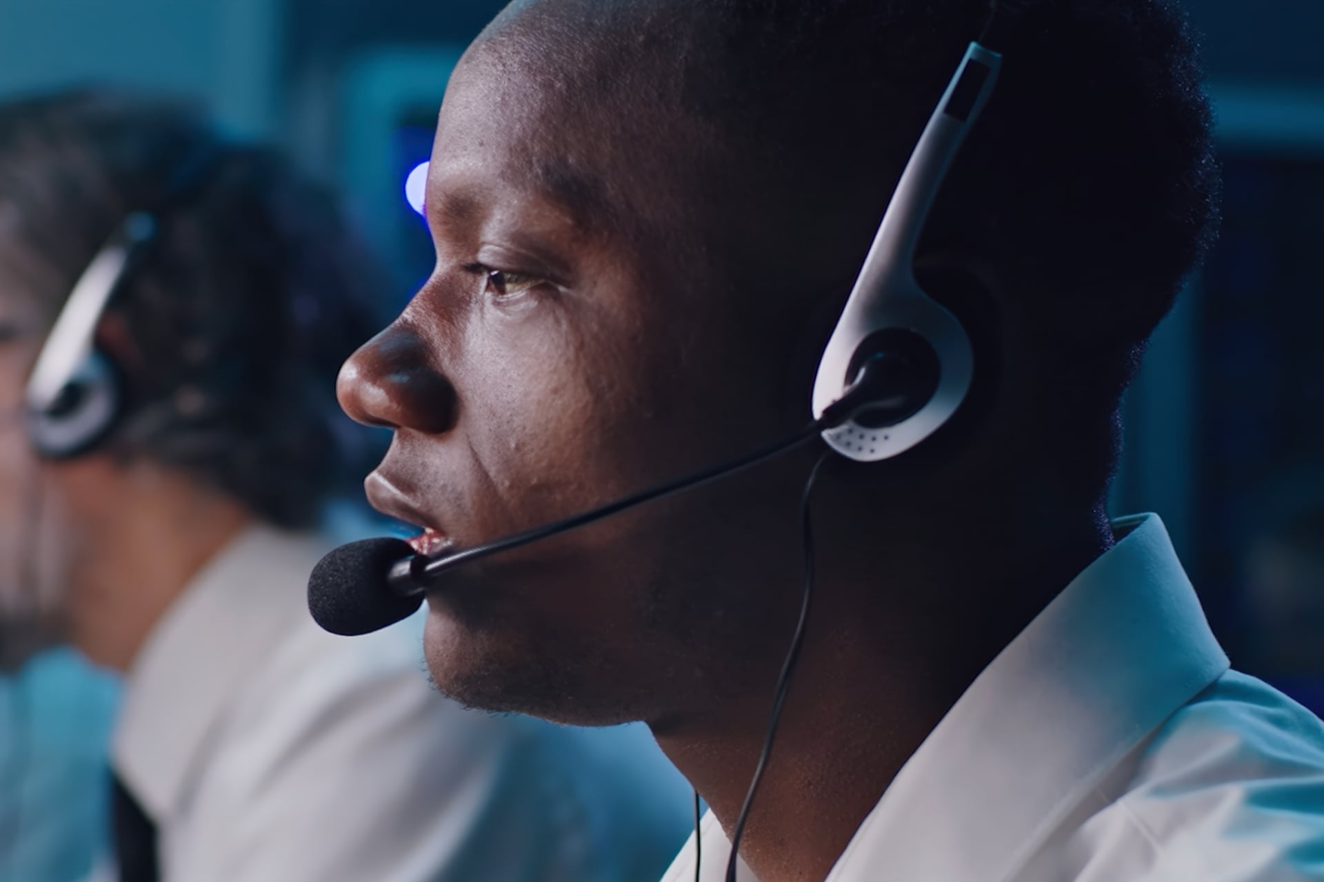 Man in business attire speaking into a headset