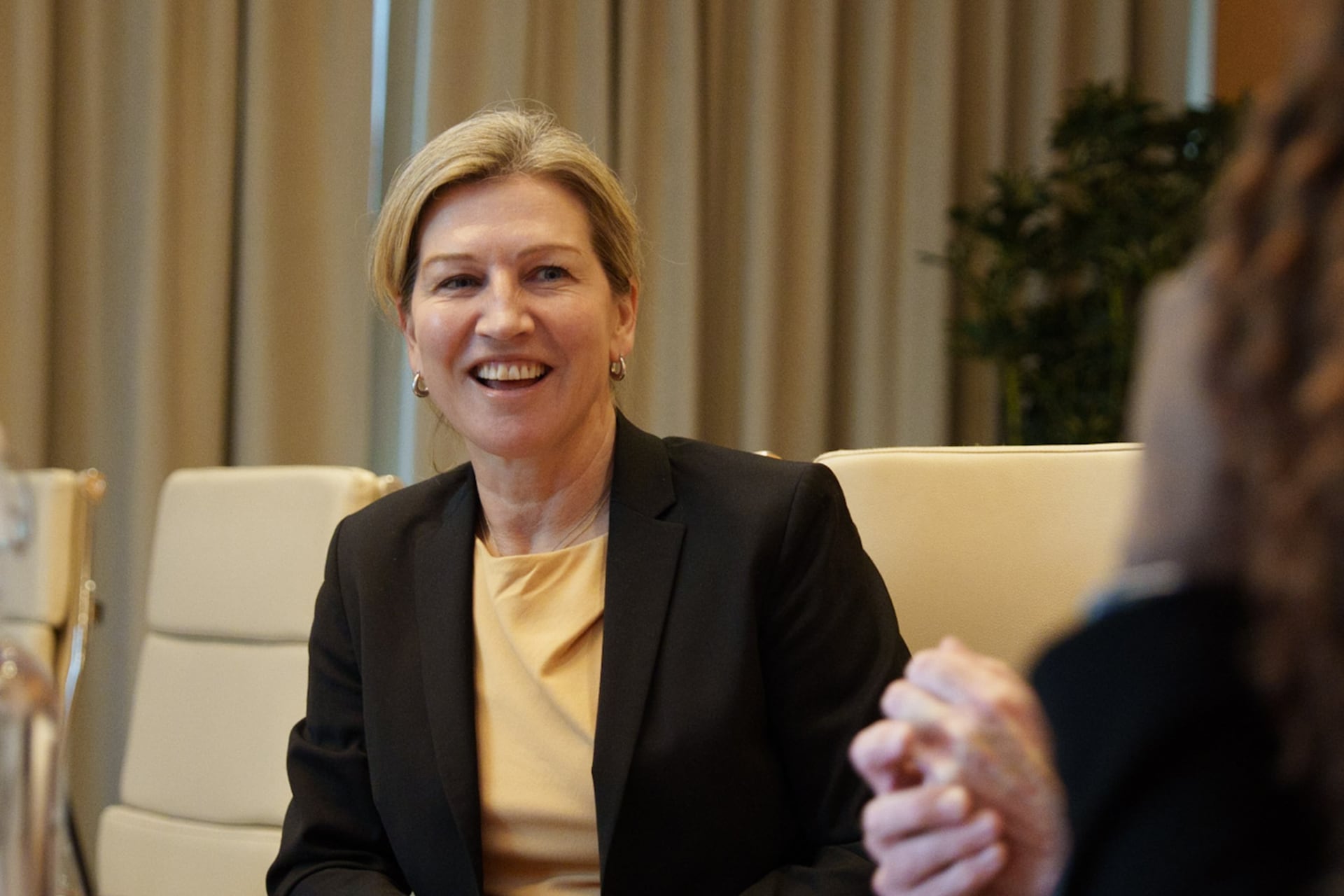 Annika Poutiainen smiling while in conversation