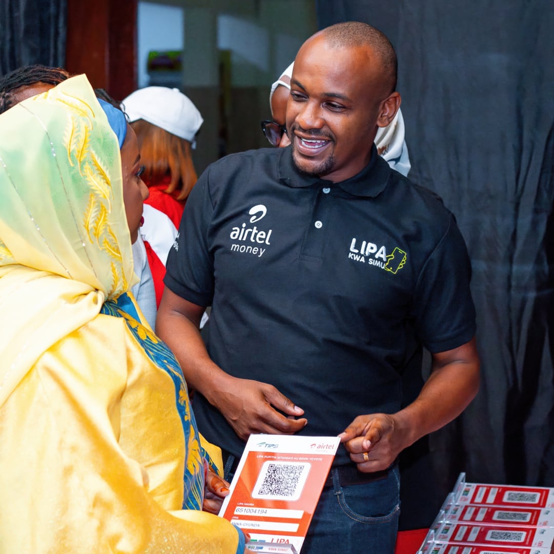 Woman talking to an Airtel Money salesman at an event