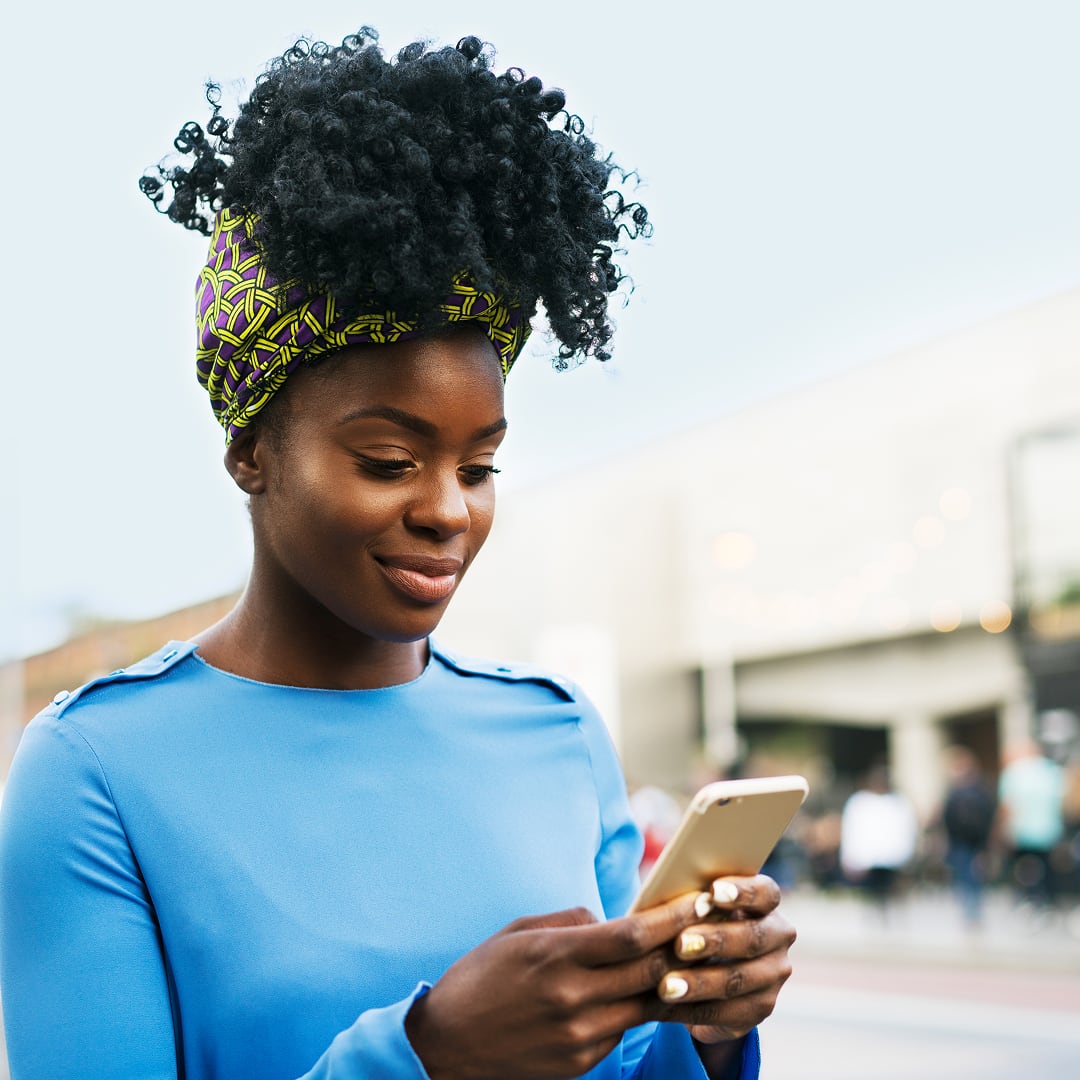 African woman using smart phone on street