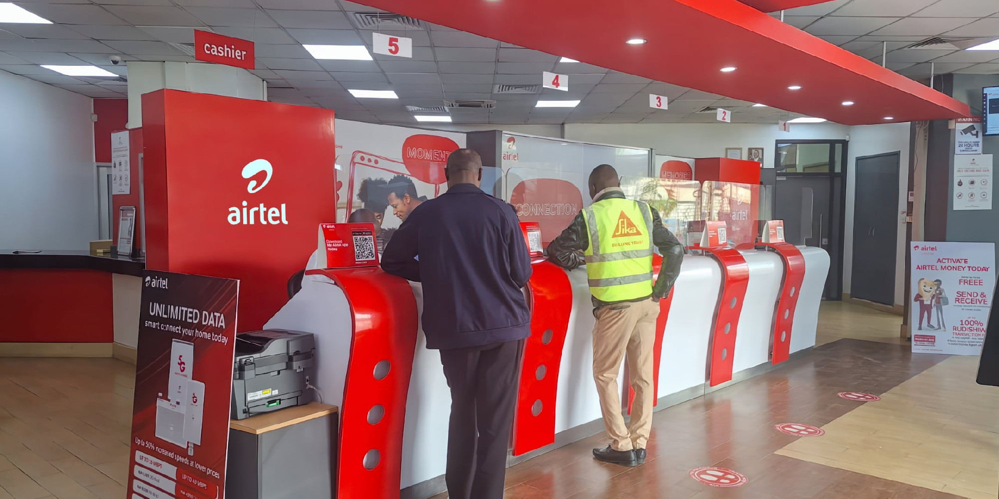 Customers being served  at the counters of an Airtel store