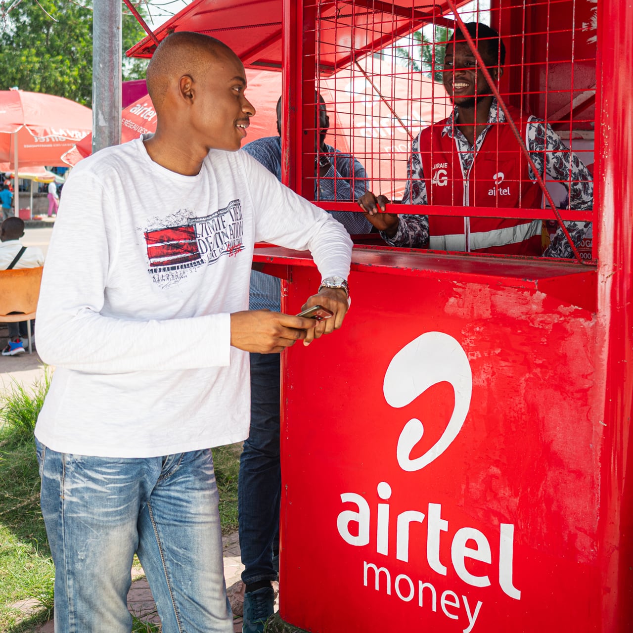 A young man talking to shop keeper at an Airtel Africa kiosk