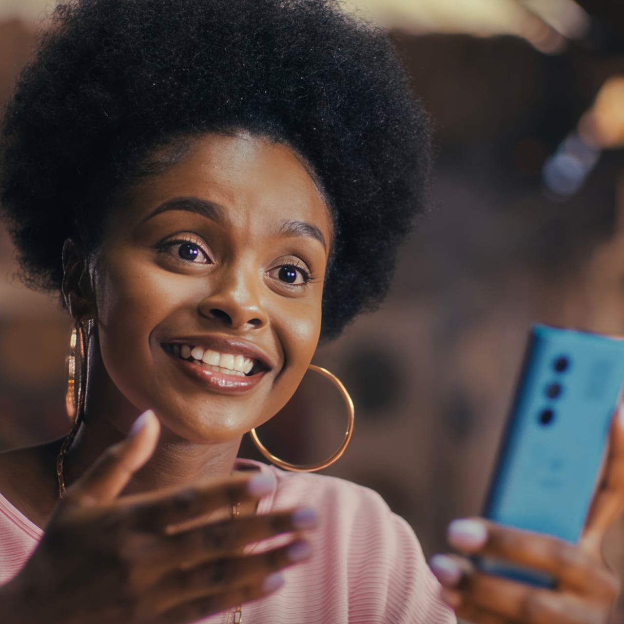Woman looking up from her phone with a smile